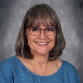 A person wearing glasses smilingDescription automatically generated with low confidence